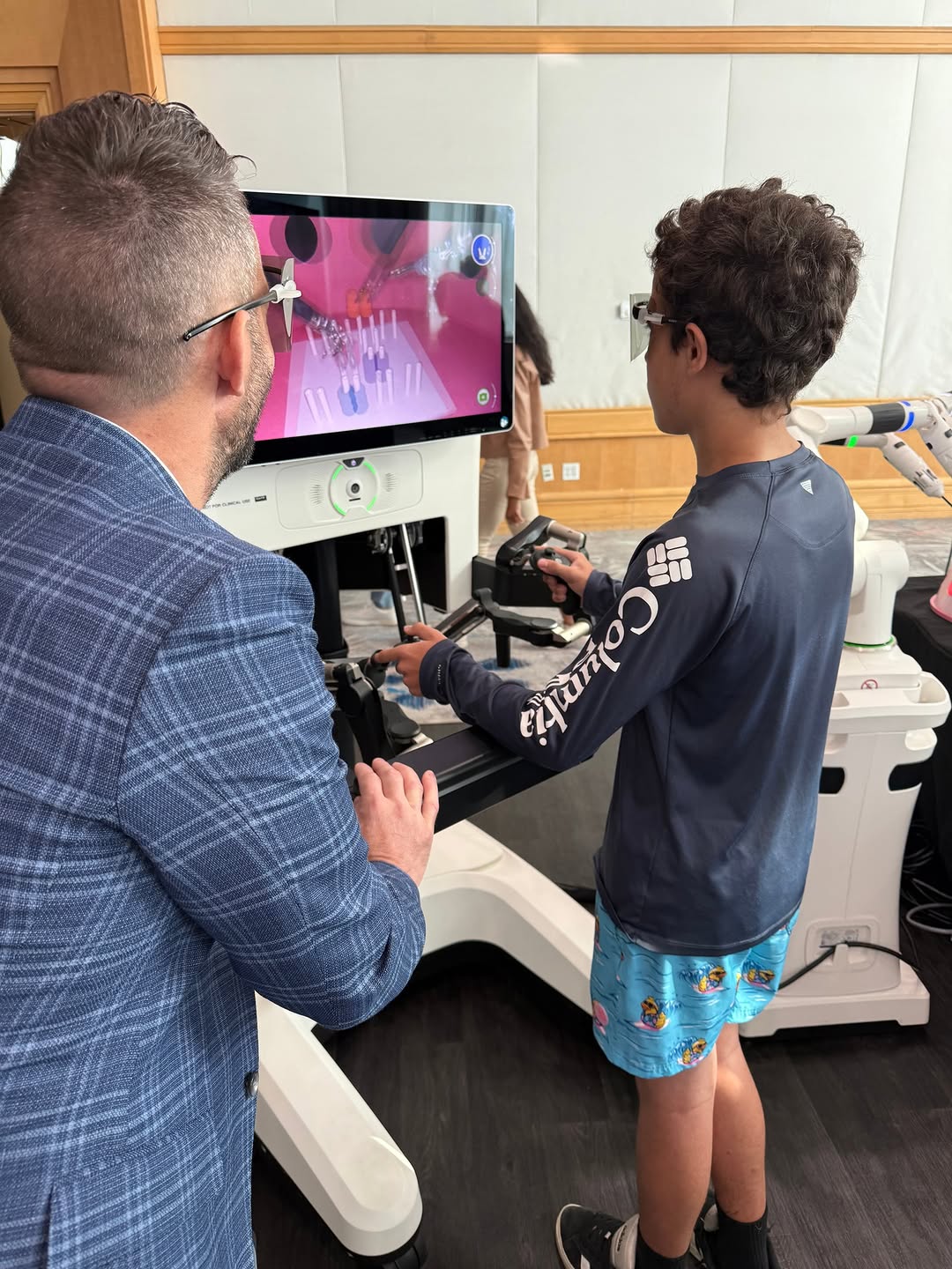 Instagram post by Dr. Aileen Caceres: One of my favorite moments this week wasn't in the operating room or during my presentation—it was watching my sons experience the Da Vinci …