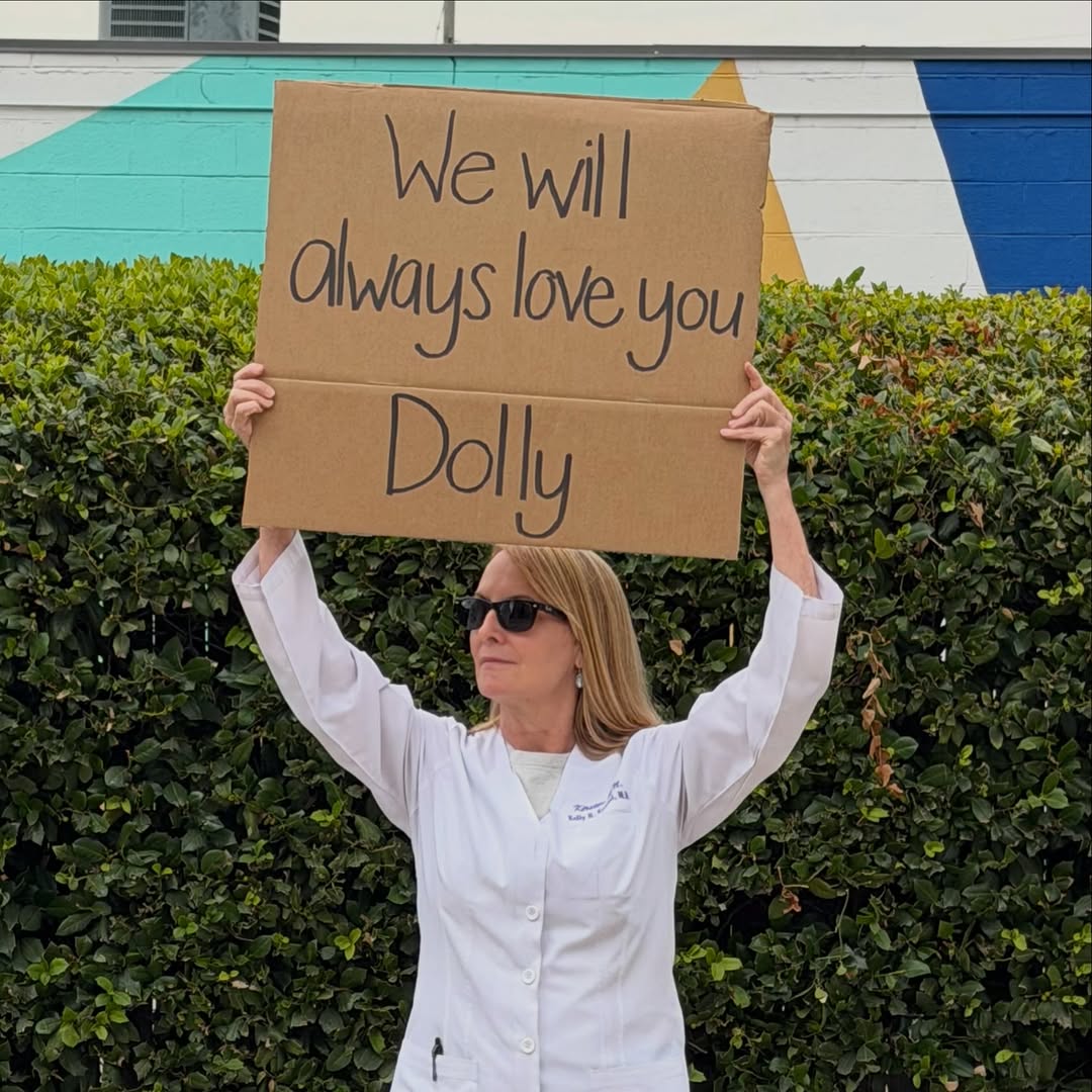 Instagram post by Dr. Kelly R. Kunkel: “If you see someone without a smile, give’em yours.”-Dolly Parton #dollyparton #nursewithsign #kurvesbykunkel #plasticsurgery