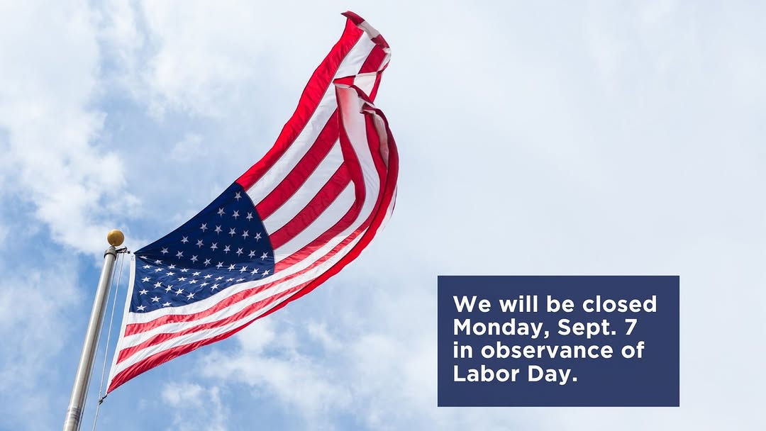 The image shows the American flag waving against a blue sky with clouds. A text box on the right side reads: "We will be closed Monday, Sept. 7 in observance of Labor Day."