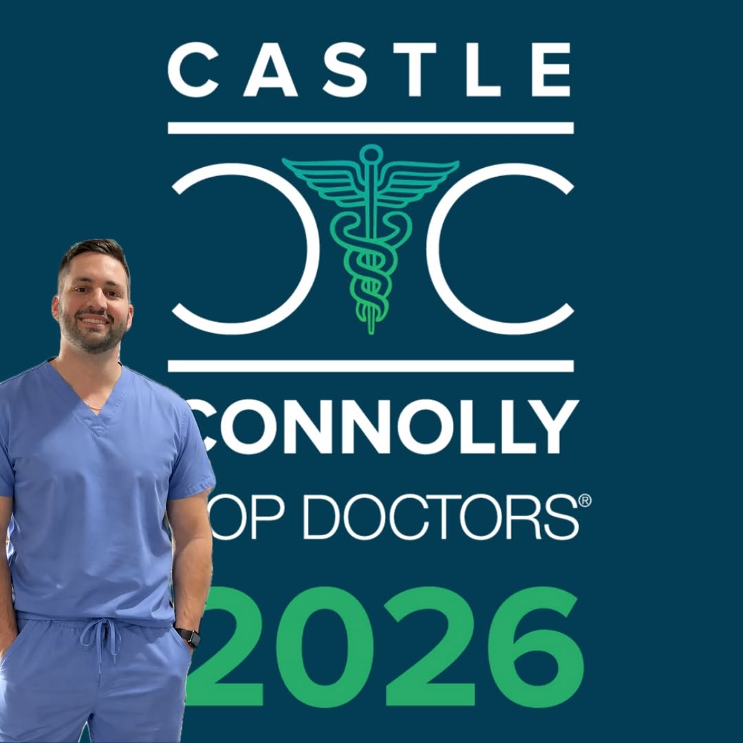 Dr. James Economides, board-certified plastic surgeon in the Washington, DC and Arlington, Virginia area, wearing blue scrubs and smiling in a portrait celebrating his recognition as a Castle Connolly